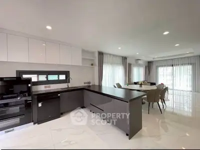 Modern kitchen with sleek cabinets and open dining area, perfect for entertaining.