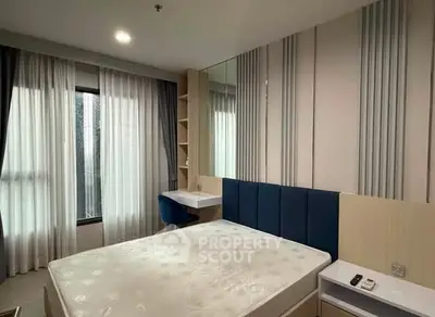 Modern bedroom with stylish decor and ample natural light, featuring a comfortable bed and study area.
