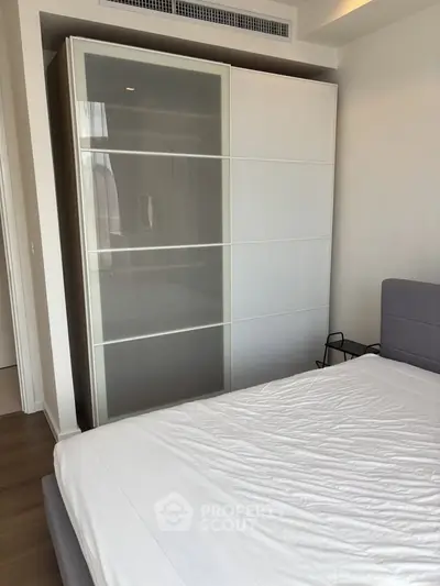 Modern bedroom with sleek wardrobe and comfortable bed in a stylish apartment.