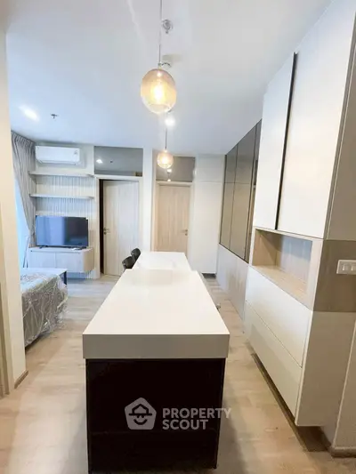 Modern kitchen with sleek design and open layout, featuring stylish lighting and ample storage space.