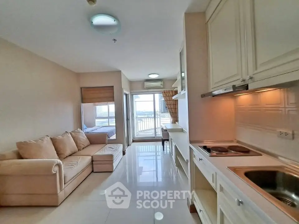 Modern open-plan living room with kitchen and balcony view