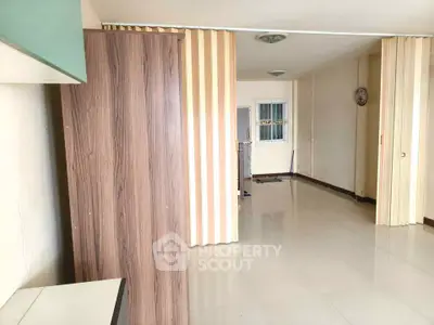 Spacious interior with modern partition and glossy tiled flooring, ideal for versatile living arrangements.
