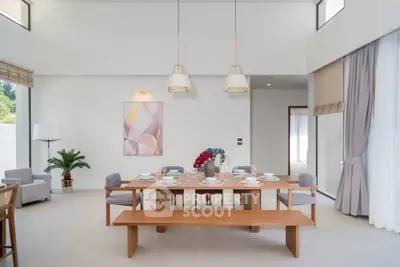 Elegant dining room with modern decor and natural light, featuring a spacious wooden table and stylish lighting.
