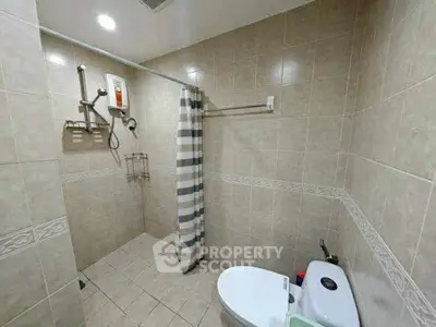 Spacious bathroom with modern shower and tiled walls