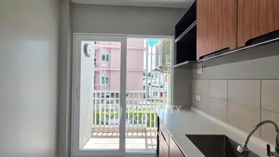 Modern kitchen with sleek cabinetry and balcony view in urban apartment