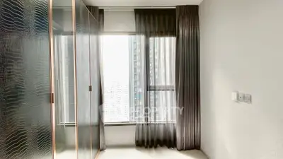 Modern bedroom with floor-to-ceiling window and sleek wardrobe design