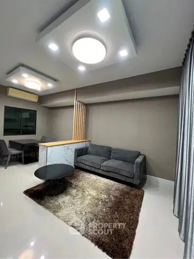Modern living room with stylish lighting and cozy seating area.