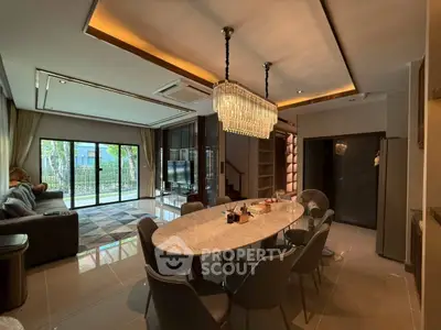Luxurious open-plan living and dining area with elegant chandelier and modern furnishings.