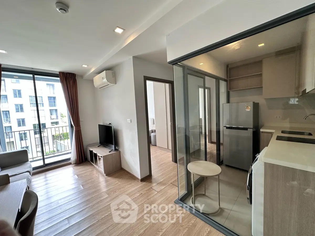 Modern apartment interior with open layout, featuring a cozy living room and sleek kitchen.