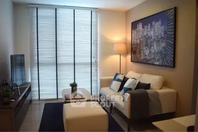 Modern living room with stylish decor and cityscape artwork, featuring a cozy sofa and natural light.