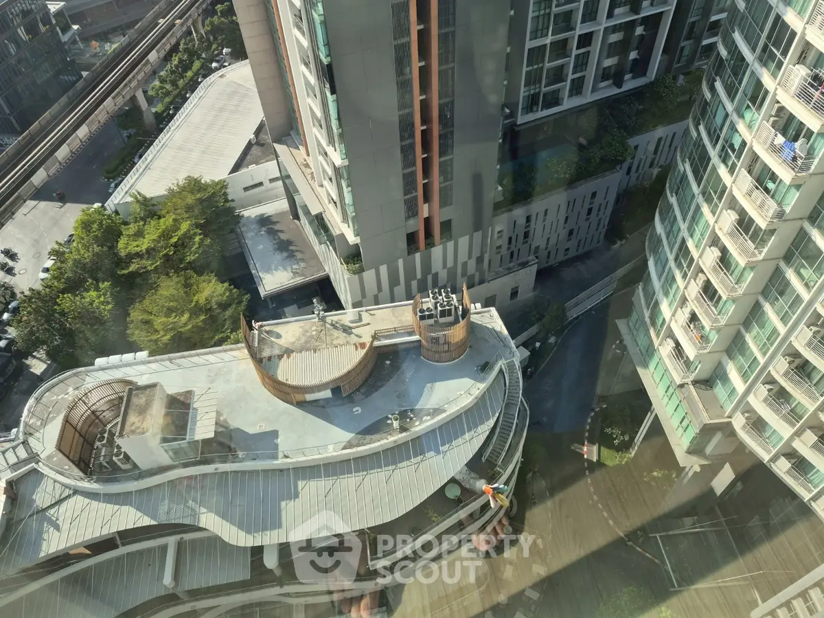 Stunning aerial view of modern high-rise buildings with lush greenery and urban landscape.