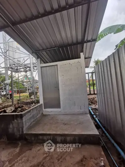 Small outdoor storage shed with metal roof and door