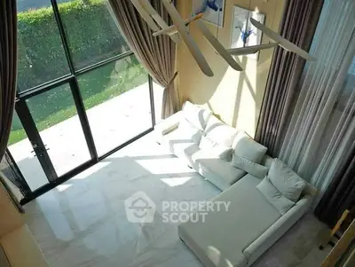 Spacious living room with floor-to-ceiling windows and modern white sofa.
