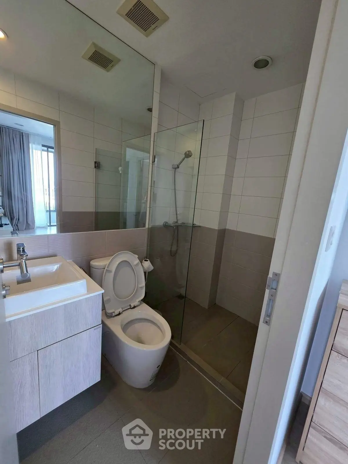 Modern bathroom with glass shower and sleek fixtures in a contemporary apartment.