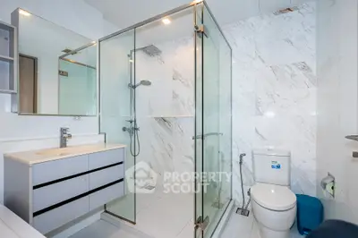 Modern bathroom with glass shower and sleek vanity in luxury apartment