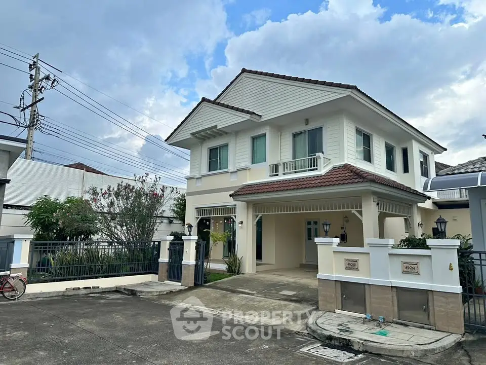 Charming two-story house with a tiled roof and spacious driveway in a serene neighborhood.