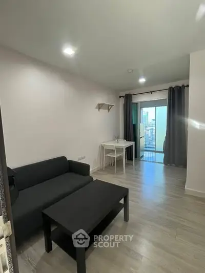 Modern living room with sleek furniture and balcony view in a stylish apartment.