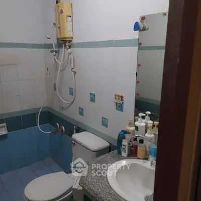 Compact bathroom with shower, toilet, and sink in a cozy real estate property.