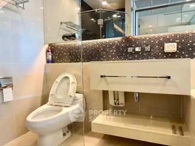 Modern bathroom with sleek fixtures and mosaic tile accents in a luxury apartment.