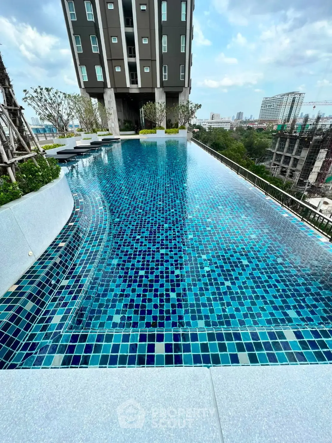 Luxurious rooftop infinity pool with stunning city views in modern high-rise building.