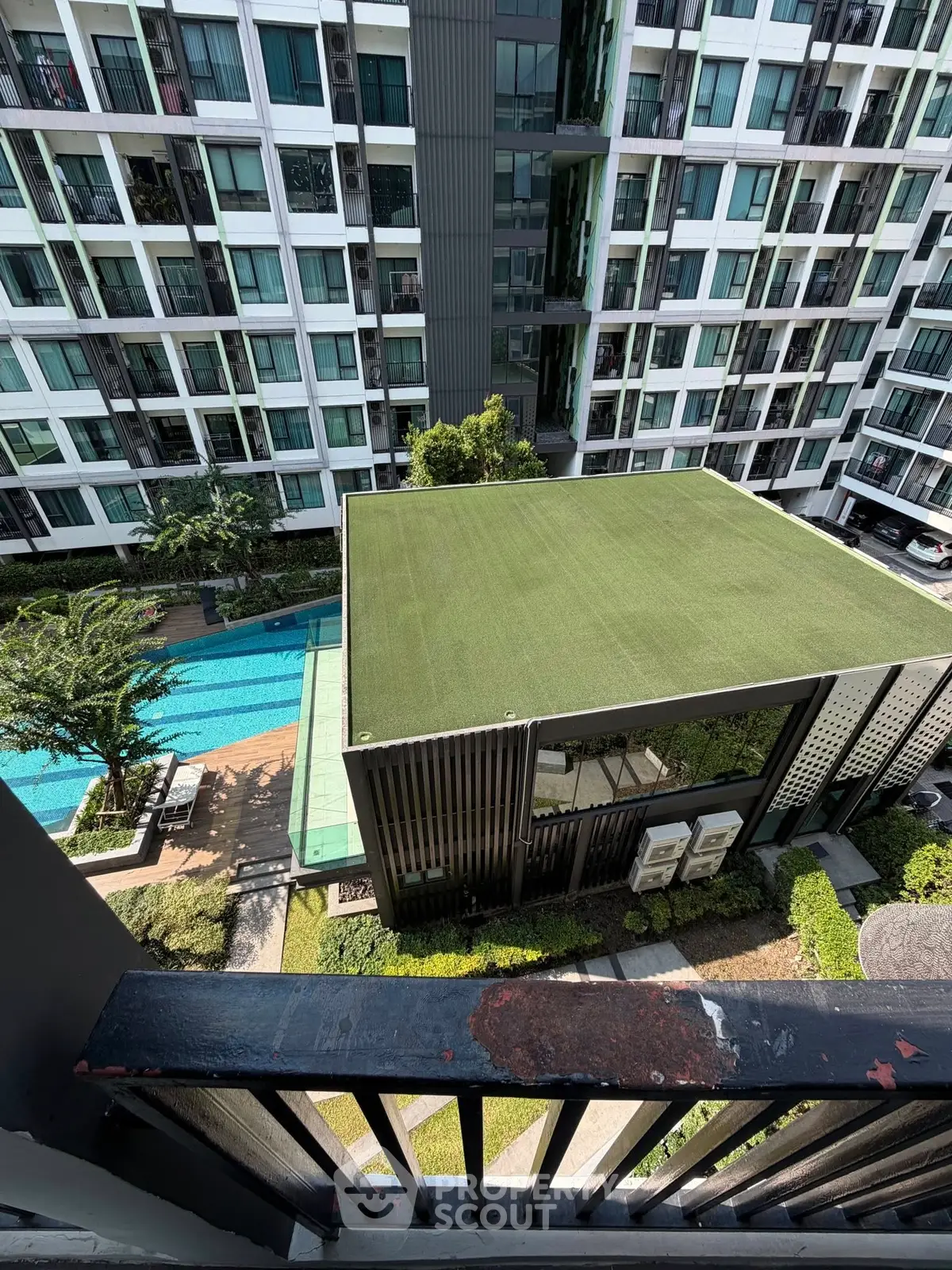 Modern apartment complex with pool and green rooftop view from balcony