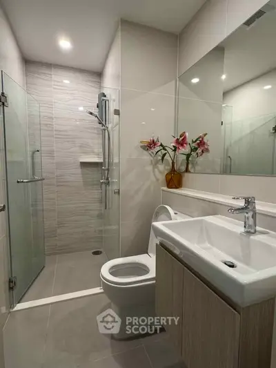 Modern bathroom with glass shower and elegant fixtures in a contemporary apartment.