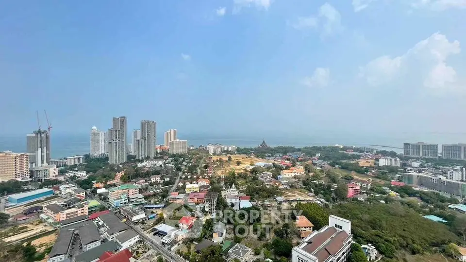 Stunning panoramic view of coastal cityscape with high-rise buildings and ocean horizon.