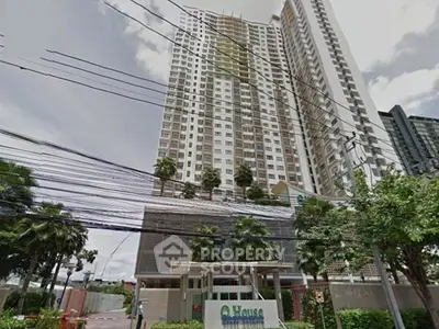 Modern high-rise condominium with lush greenery and urban surroundings.