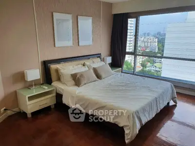 Spacious bedroom with large window offering stunning city views, featuring elegant decor and cozy bedding.