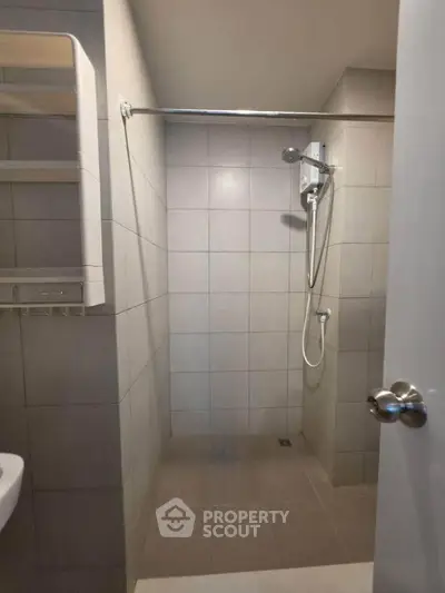 Modern minimalist bathroom with tiled shower area and sleek fixtures.