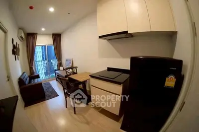 Modern apartment with compact kitchen and cozy living area, featuring a balcony with city view.