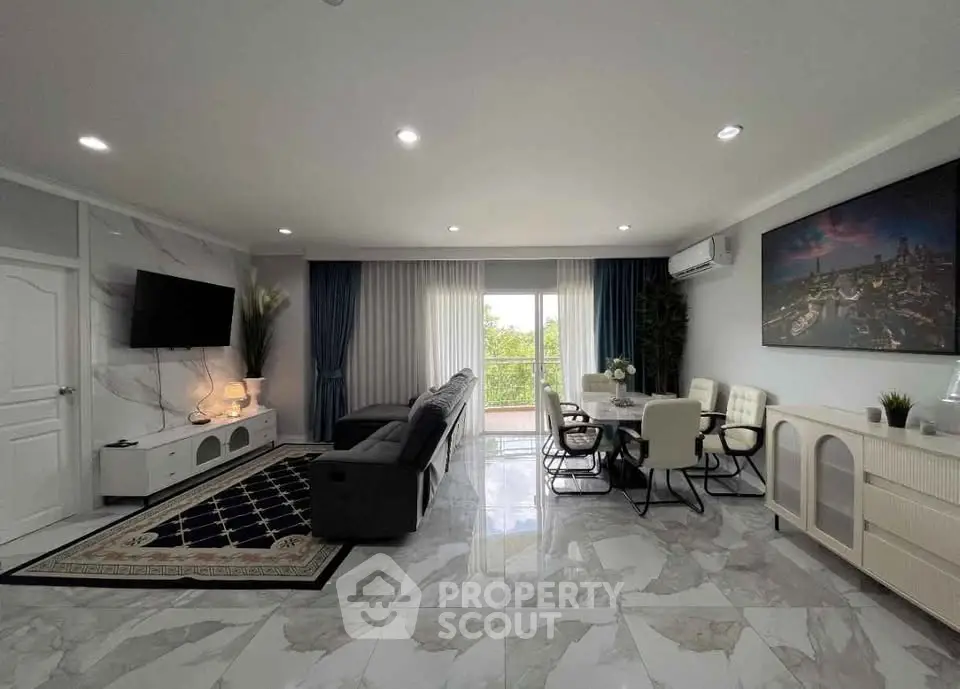 Spacious modern living room with elegant decor and large windows offering natural light.