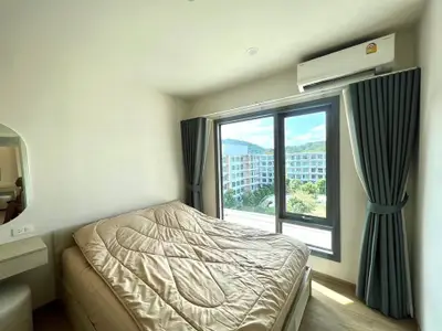 Bright bedroom with large window and scenic view in modern apartment