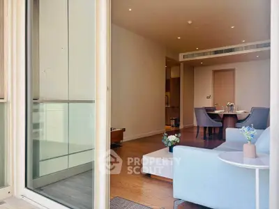 Spacious living room with modern decor and dining area, featuring elegant furniture and natural light.
