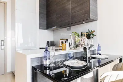 Modern kitchen with sleek design, featuring a dining area with elegant table settings and contemporary cabinetry.