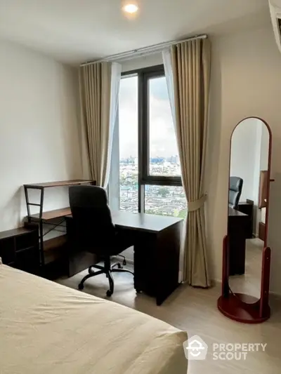 Modern bedroom with study area and city view, featuring a desk, chair, and mirror.