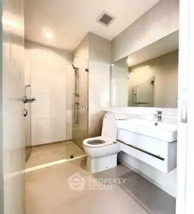 Modern bathroom with sleek fixtures and spacious shower in a contemporary home.