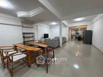 Spacious open-plan living and dining area with modern furnishings and tiled flooring.