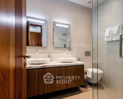 Luxurious modern bathroom with dual sinks and elegant wooden cabinetry.