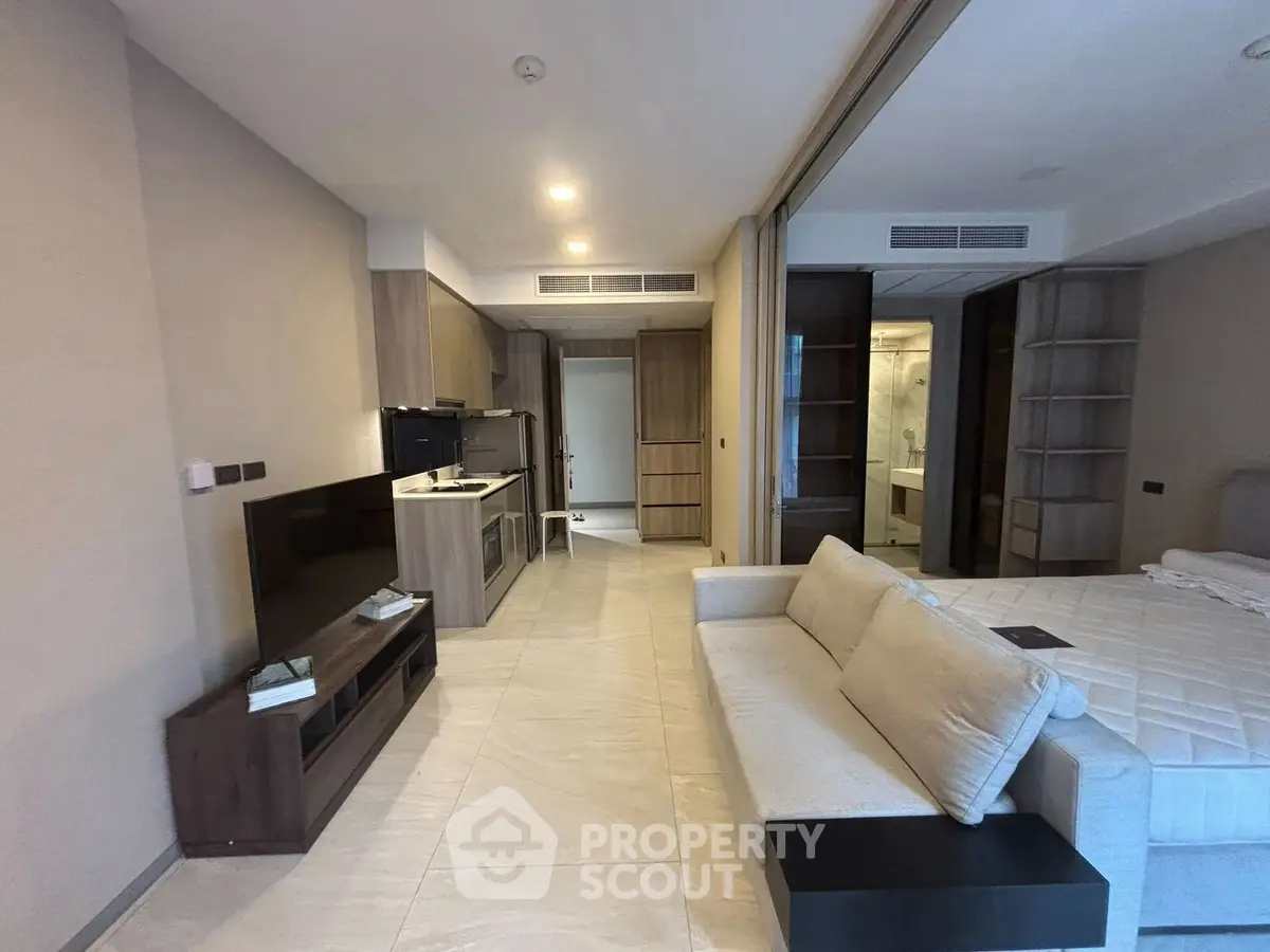 Modern studio apartment with open layout, featuring a cozy living area and compact kitchen.