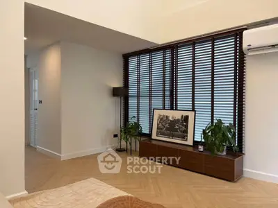 Modern living room with wooden flooring, stylish blinds, and elegant decor