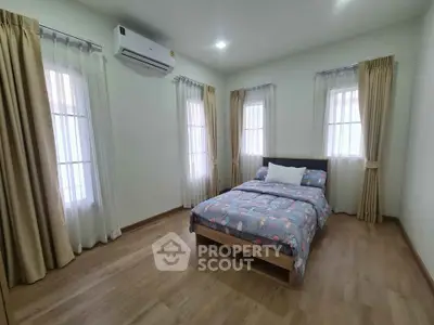 Spacious bedroom with natural light and modern decor in a cozy home.