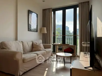 Bright living room with large windows and cozy sofa, offering a serene view of the cityscape.