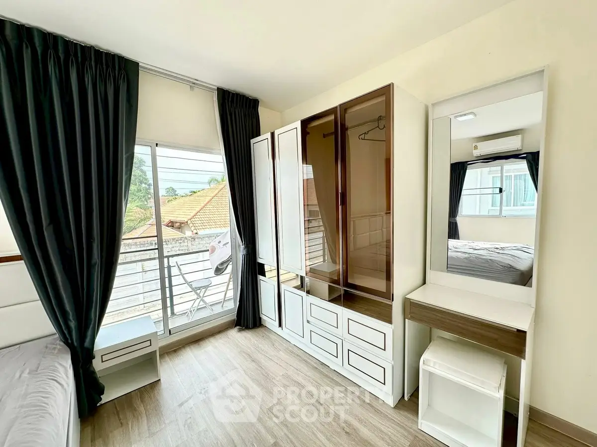 Bright bedroom with modern furniture and large window offering natural light.