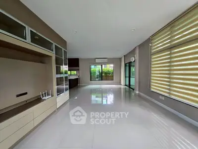 Spacious modern living room with large windows and sleek built-in storage