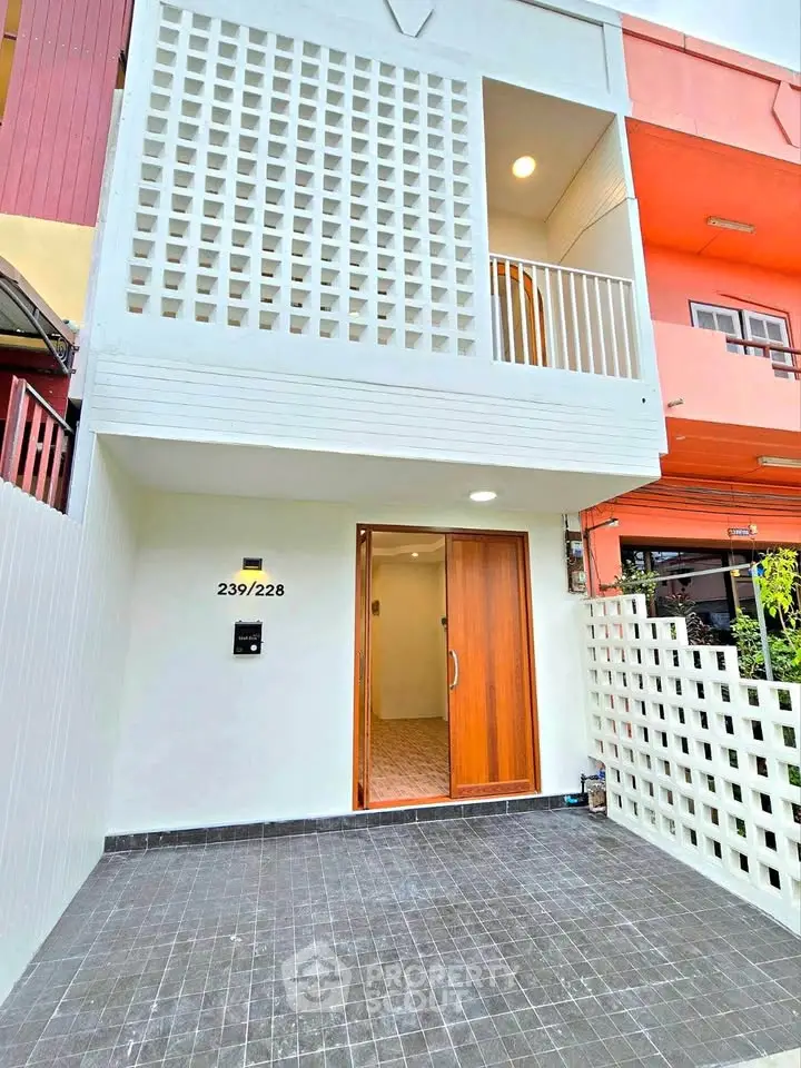 Modern townhouse entrance with unique facade design and wooden door