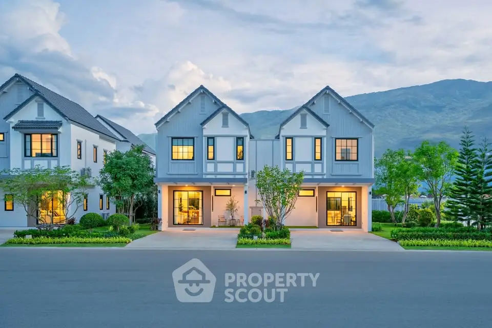 Charming modern duplex homes with mountain backdrop and lush landscaping.