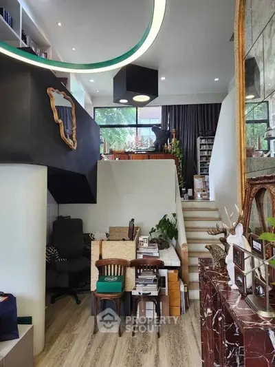 Stylish modern living room with mezzanine, elegant decor, and natural light.