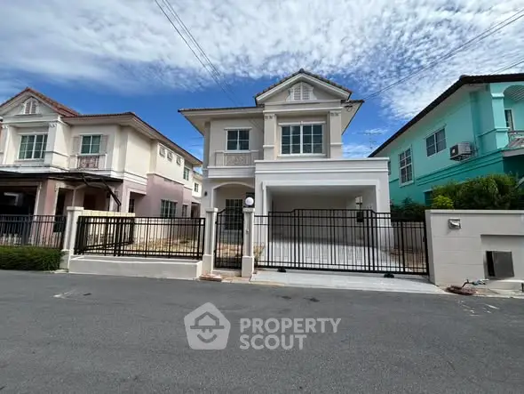 Charming two-story house with gated driveway and modern facade in a serene neighborhood.
