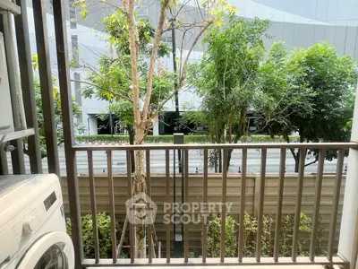Charming balcony view with lush greenery and modern washing machine setup.